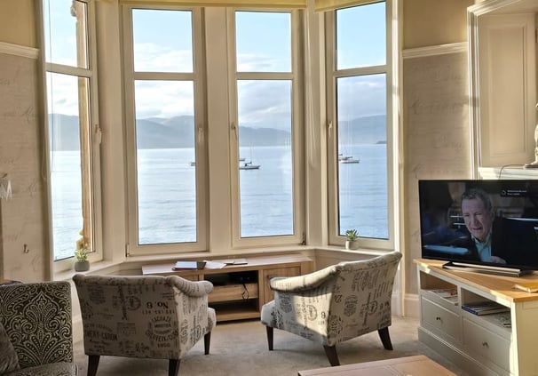 The living room at Gourock Seaview Holiday Let with a large window with sea views and a television