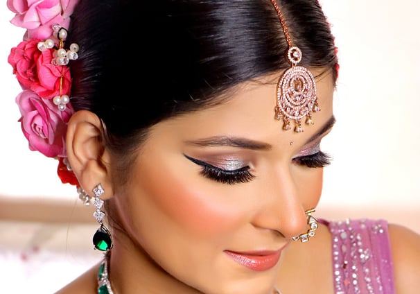 a woman in a purple dress with a necklace and earrings