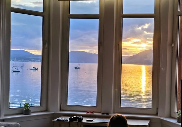 a girl sitting in a chair looking out at the ocean at Gourock Seaview Holiday Let