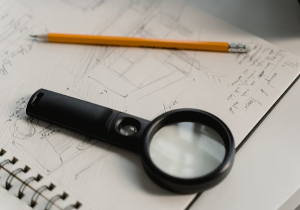 loupe et crayon - Révision et relecture pour un contrôle qualité optimum