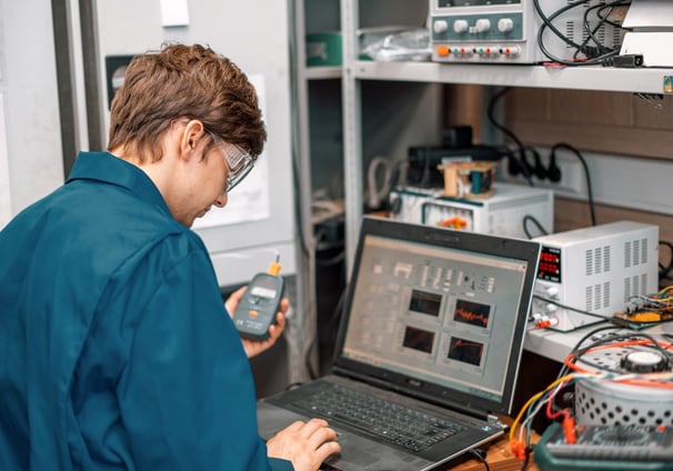 A man standing in front of a computer doing Sound Attenuation Field Testing