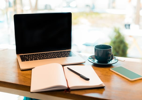 a laptop computer and a notebook on a table