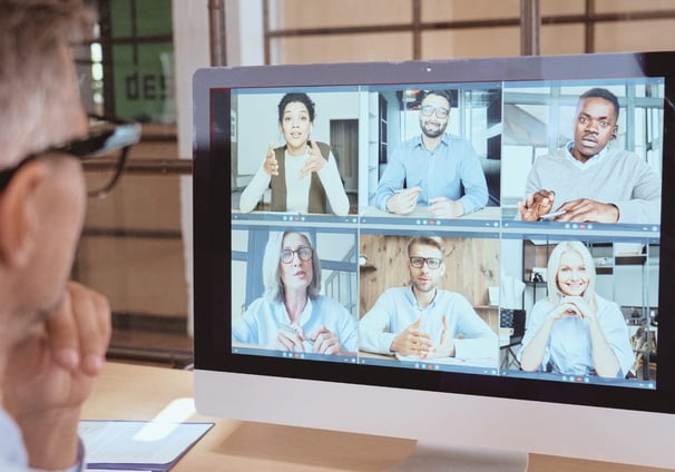 a man in a white shirt and glasses is looking at a computer screen
