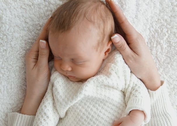a newborn baby is sleeping in a white blanket