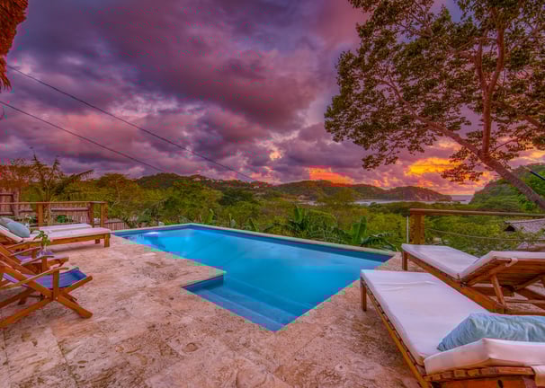 pool at sunset overlooking tropical garden and ocean at retreat center central america