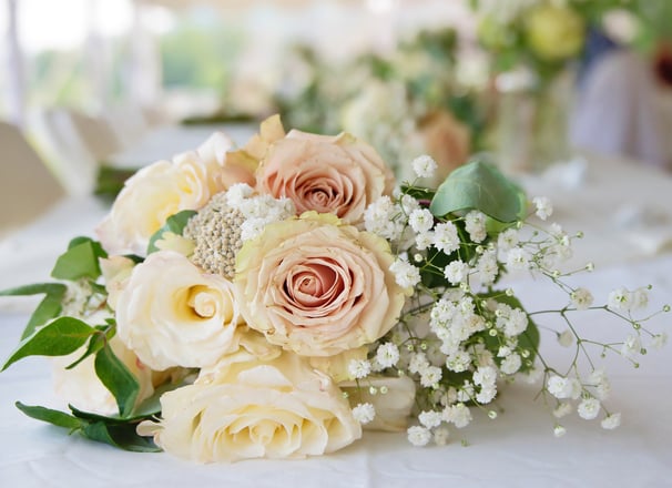a bouquet of flowers on a table in a wedding reception