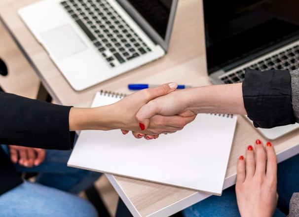a person shaking hands with a person in a suit