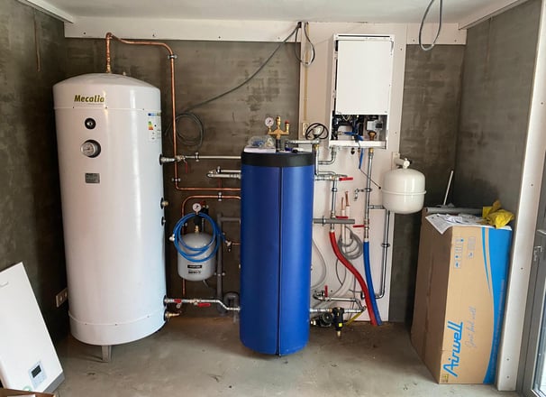 a room with a tankless water heater and a large blue tank