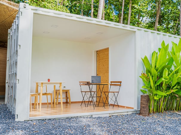 a small container house with a laptop on the ground