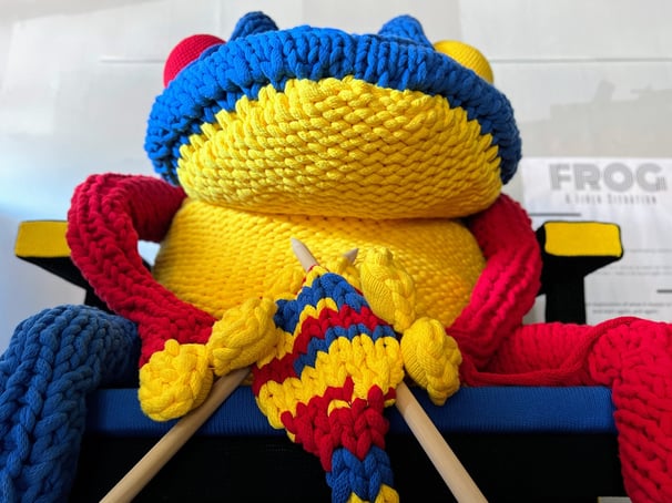 FROG knitting on Rietveld chair with giant knitting needles by Dundee & Lee