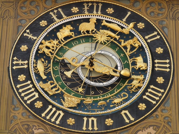 simbolički prikaz sata s astrološkim simbolima