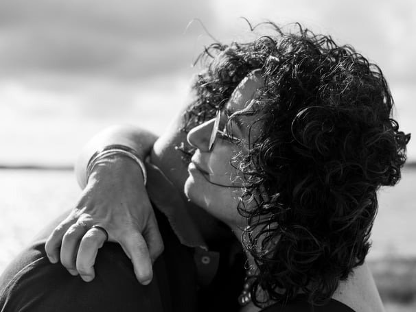 Plan rapproché d'un couple s'enlaçant sur la plage lors d'une séance photo au bassin d'arcachon