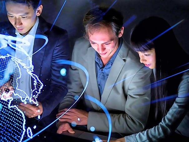 Two female and two male leaders using smart devices in front of a holographic globe