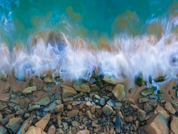 a wave crashing over rocks and rocks