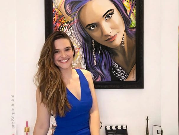 Um cliente sorrindo enquanto observa sua nova pintura Pop-Art personalizada em casa.