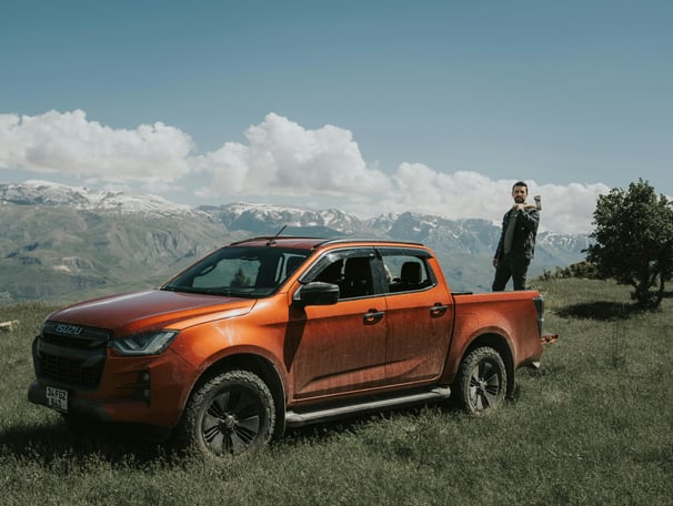 Orange Suzuki Pick-Up against mountain brackgraund