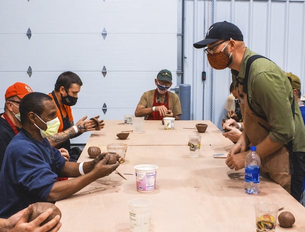 Image of an instructor leading a clay project in front of our Veteran class.