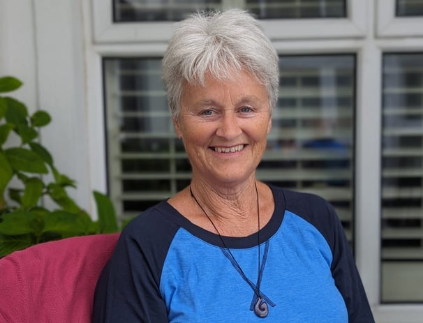 a woman sitting on a couch with a necklace necklace