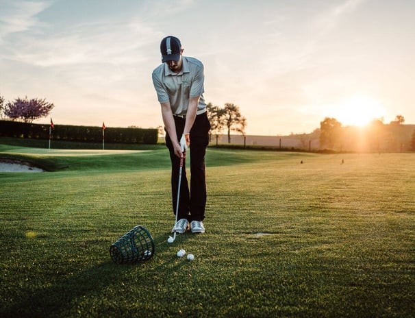 Dein Selbstführung Mentor konzentriert auf einem Golfplatz bei Sonnenuntergang