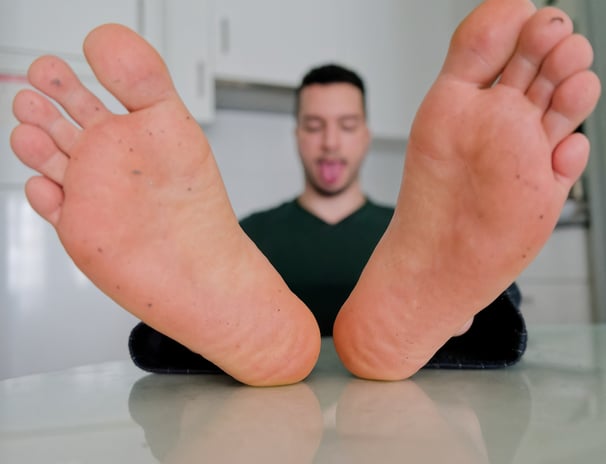 a man with his tongue out and showing dirty feet