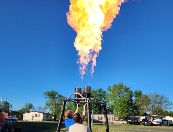 a man is standing in front of a hot air balloon