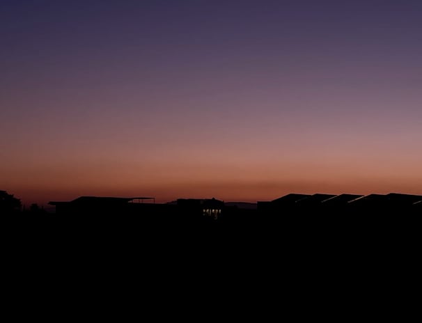 a person standing on a hill with a sky background