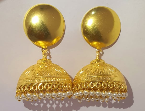 a pair of gold toned earrings with pearls and pearls