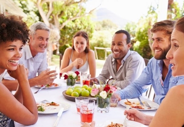 people gathering around a picnic table having a fun discussion
