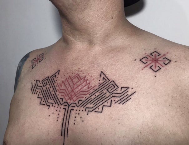 An handpoked tattoo featuring geomatric ornaments tappis pattrens inspired, tattoo on chest