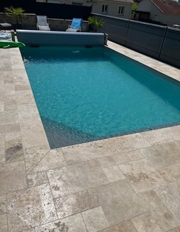 Piscine avec sol carrelé et décor serein en fond