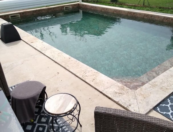 Une piscine avec un canapé et des chaises dans le jardin