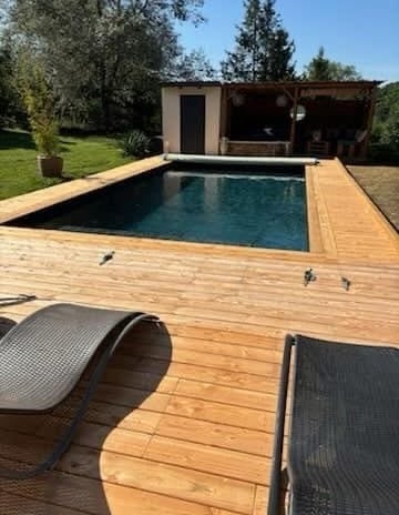Piscine naturelle, terrasse bois et chaise longue