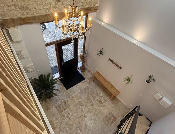 a staircase leading to a foyer with a chandelier