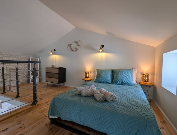 a bed with a blue bedding and a glass table