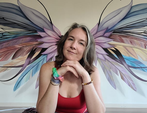 a yoga teacher with a large wings in background