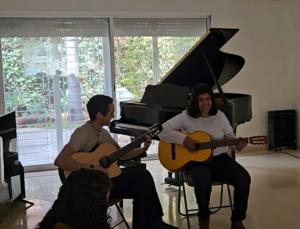 a man and woman playing guitar and guitar together