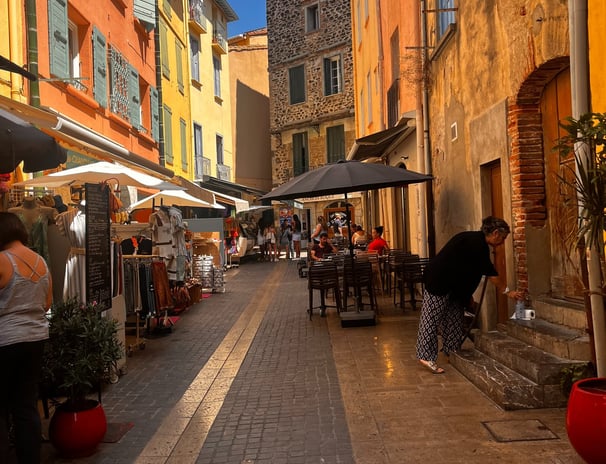 a narrow street with people walking down the street