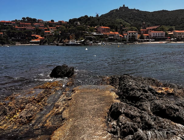 a pier with a view of a beach and a boat