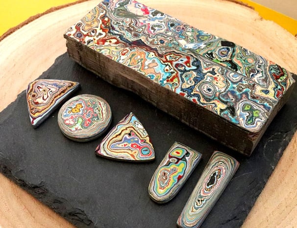 a rock slab of graffiti wall, that has been cut into cabochons to be used in jewellery 