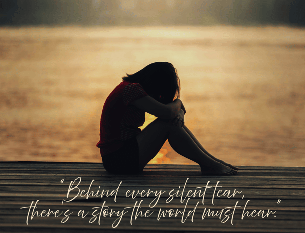 A female crying sitting by the water. “Behind every silent tear, there’s a story the world must hear