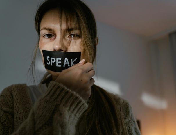 Woman with black eye with speak wrote on tape on her mouth