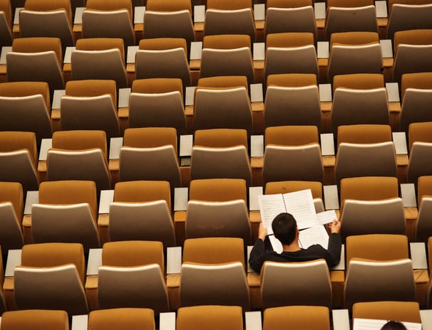 a man sitting in a chair in a room with many chairs
