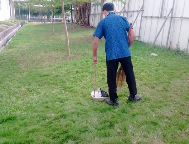 petugas kebersihan glbn yang  membersihkan halaman