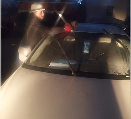 Technichian is working after dark on a windshield