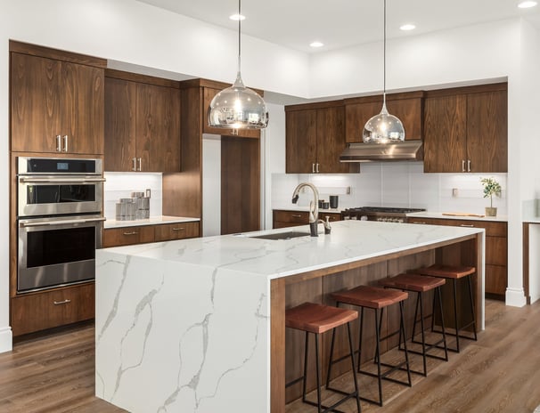 Modern kitchen renovation with marble waterfall island and wood cabinetry in London, Ontario.