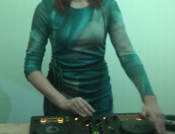 a woman in a green dress and headphones on a table