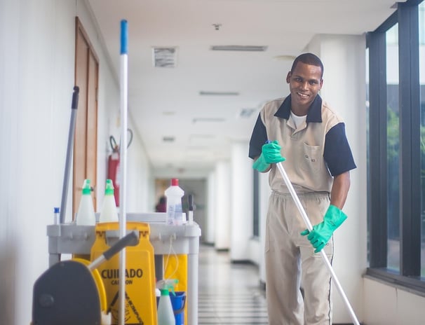 a man in a uniform cleaning a hallway