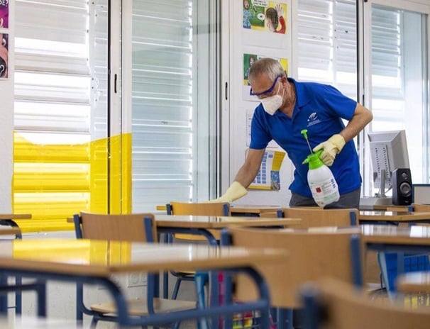 a man in a blue shirt and a white shirt cleaning a desk