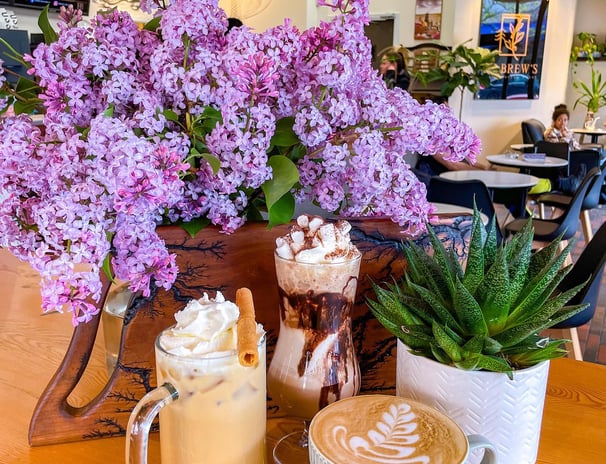 a vase of flowers and a coffee mug on a table