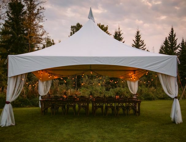 Carpa 20x20 en el patio de una casa, adornada con luces, sillas, mesas